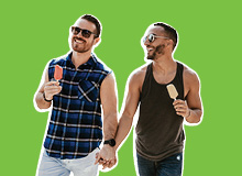 two men walking together with ice cream cones and holding hands